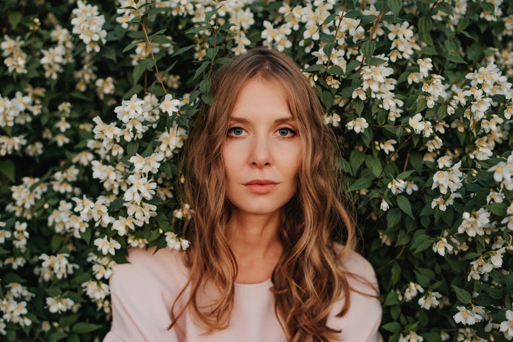 A serene and captivating female portrait amidst jasmine flowers outdoors, embracing nature's beauty.